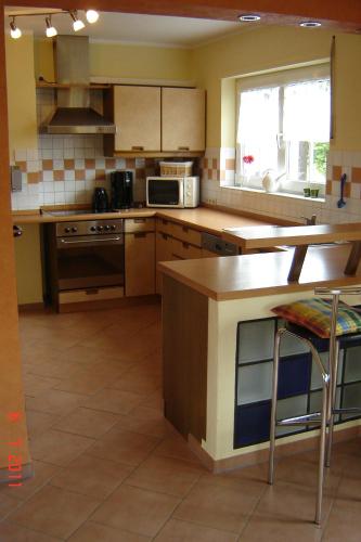 a kitchen with wooden cabinets and a counter top at Urlaub auf dem Bauernhof Marx in Kelberg