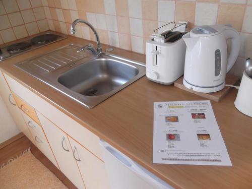 a kitchen counter with a sink and a register at 'By the Lake' Apartments in Ohrid