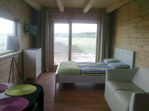 a bedroom with a bed and a couch and a window at Villa Medeina in Šventoji