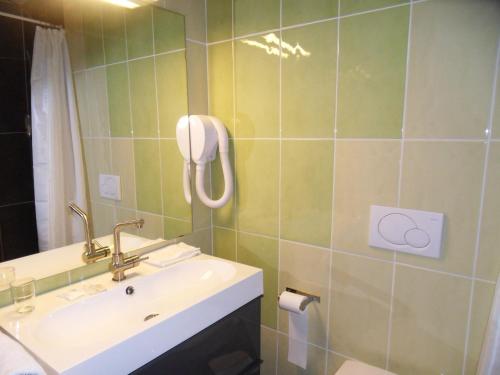 a bathroom with a sink and a phone on the wall at Savoy Hotel in Le Bourget-du-Lac