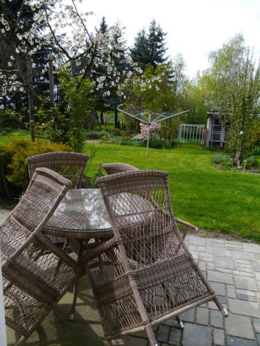 three wicker chairs and a table in a yard at Ferienwohnung im Neubauernweg 3 in Hoppegarten
