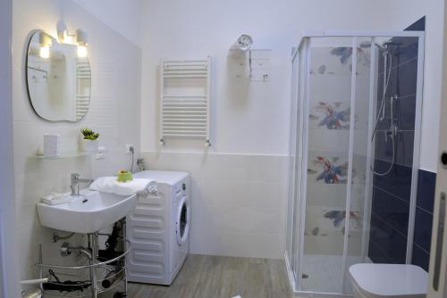 a white bathroom with a sink and a shower at Appartamento Nonna Lina in Custonaci