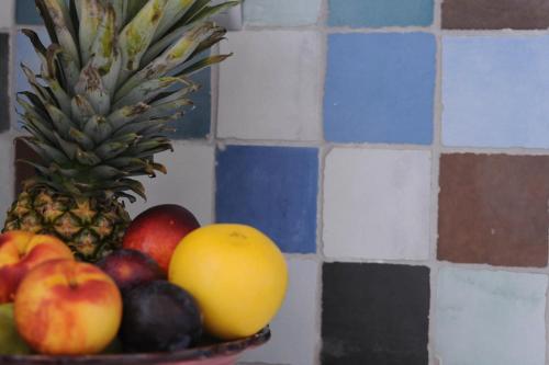 a bowl of fruit on a counter with a pineapple at Sideratos Apartments in Karfas