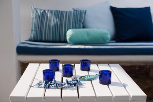 a coffee table with blue glasses on it with a couch at Sideratos Apartments in Karfas