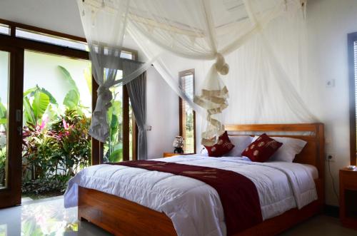 a bedroom with a bed with a canopy at Villa Ole in Ubud