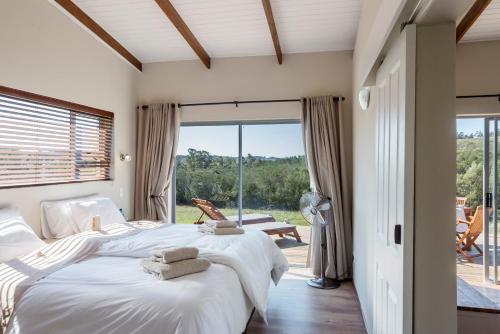 a bedroom with two beds and a large window at Stoneyvale Cottages in Grahamstown
