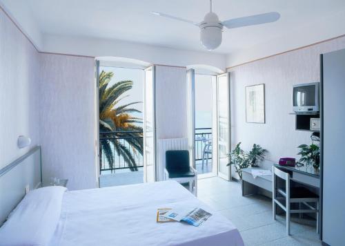 アラッシオにあるHotel Danio Lungomareのベッドとバルコニー付きのホテルルーム