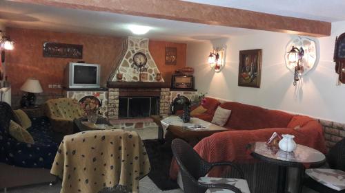 a living room with a couch and a fireplace at Germanos Studios in Kato Loutraki