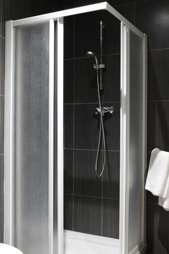 y baño con ducha y puerta de cristal. en Hotel Restaurante Sonsoles, en Ávila