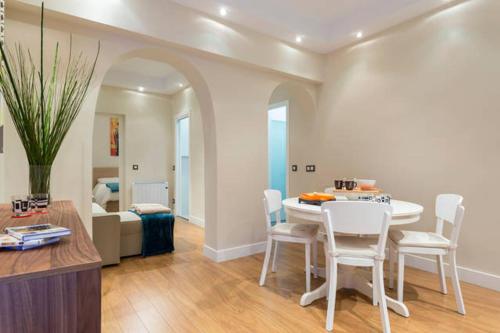 a living room with a table and white chairs at Puerta del Sol Center in Madrid