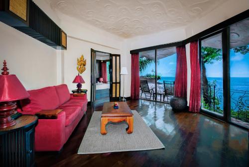 a living room with a red couch and a table at Jamahkiri Dive Resort & Spa in Koh Tao