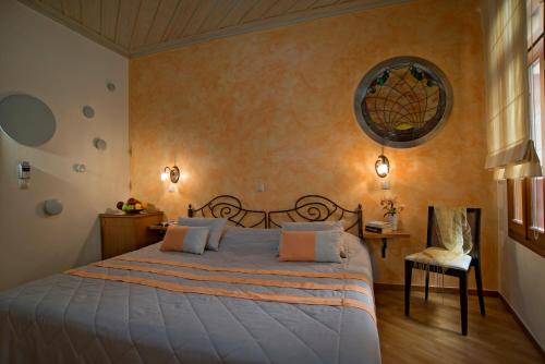 a bedroom with a large bed and a chair at Ionas Boutique Hotel in Chania Town