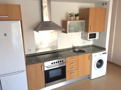 a small kitchen with a stove and a sink at Hola Apartments 1-30 in Playa de San Juan