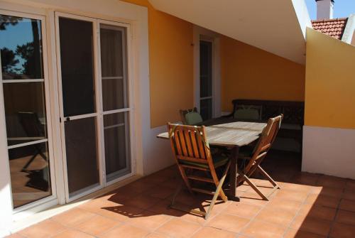 a dining room table and chairs on a patio at Aldeamento Turistico Casas da Comporta in Comporta
