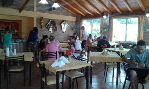 a group of people sitting at tables in a restaurant at Hotel La Lucre in Mina Clavero