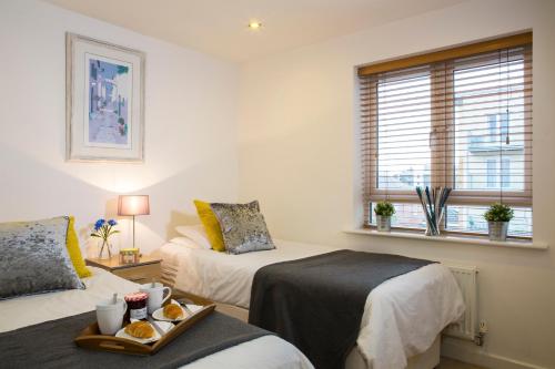 um quarto com duas camas e uma bandeja de comida em Borehamwood - Spacious Apartment em Borehamwood