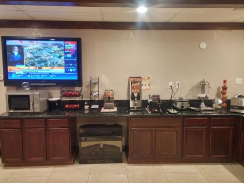 a kitchen with a large tv on the wall at Ramada by Wyndham Grand Junction in Grand Junction