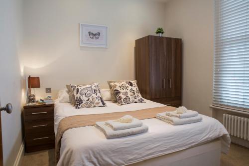 ein Schlafzimmer mit 2 Betten und Handtüchern darauf in der Unterkunft Finchley Central Spacious 3 bed triplex loft style apartment in Hendon