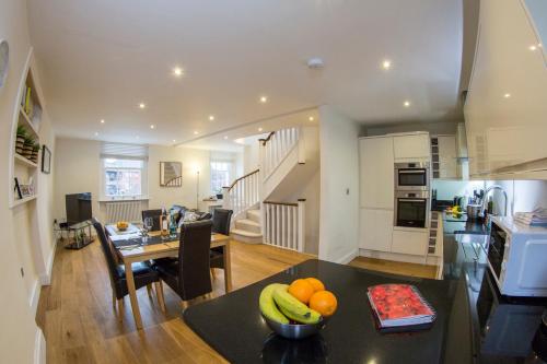 a kitchen and living room with a table with fruit on it at Finchley Central Spacious 3 bed triplex loft style apartment in Hendon