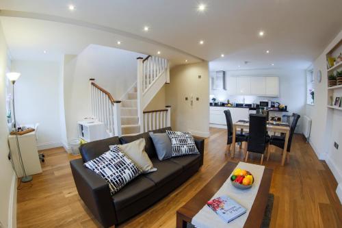 a living room with a black couch and a table at Finchley Central Spacious 3 bed triplex loft style apartment in Hendon