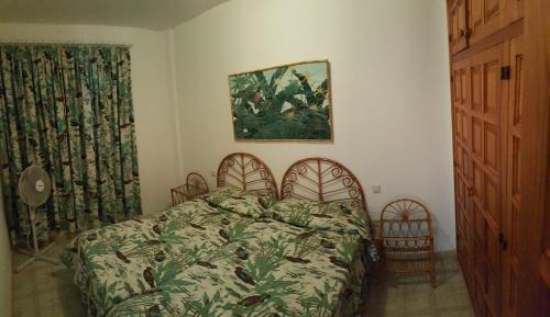 Los CarrizalesにあるApartments Gigantes Sunrisesのベッドルーム1室(ベッド1台付)が備わります。壁には絵画が飾られています。
