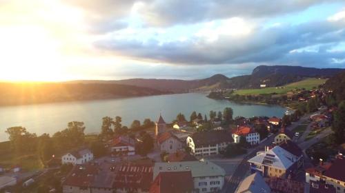 a town next to a body of water with buildings at HÔTEL DE VILLE - La Baie Du Lac in LʼAbbaye