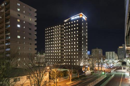 un edificio alto con un cartel en la parte superior en APA Hotel Fukushima Ekimae en Fukushima