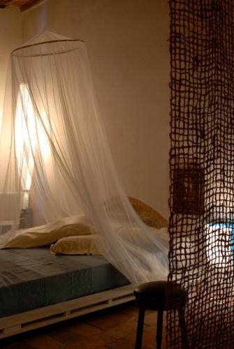 a bedroom with a bed with a mosquito net at Morelliana4Rooms in Scansano