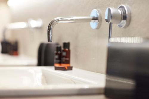 a bathroom sink with a faucet on a counter at Hotel Nelson in Knokke-Heist