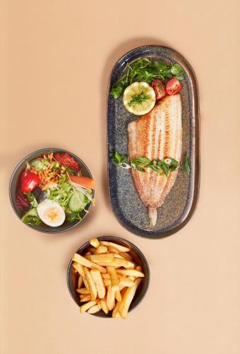 three plates of food with french fries on a table at Hotel Nelson in Knokke-Heist
