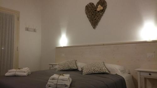 a bedroom with a bed with pillows and a heart on the wall at Agriturismo Honey Farm in Piazzola sul Brenta