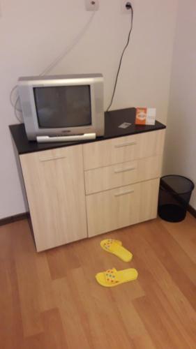 a room with a tv and a pair of slippers on the floor at Magnolia Guest house in Haskovo