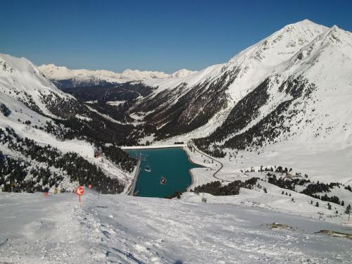 a view of a mountain with a lake in the snow at Modern ski-in Appartement 2020m Kühtai in Kühtai