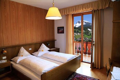 a bedroom with a bed with a view of a mountain at Garni Panoramik in Ortisei