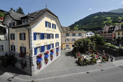 a white building with blue windows and flowers on it at Hotel Krone in Schruns-Tschagguns