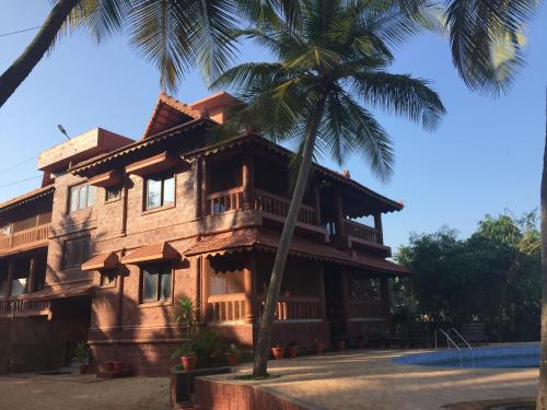 a house with a palm tree in front of it at Paradise Lagoon in Kalyānpur