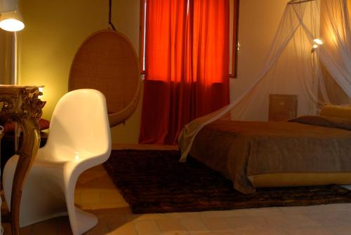 a bedroom with a bed and a chair and a table at Morelliana4Rooms in Scansano