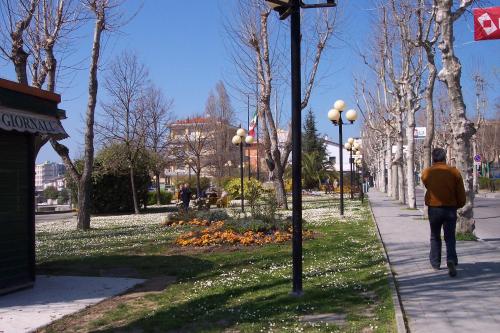 a man walking down a sidewalk in a park at Da Lorella in Gabicce Mare