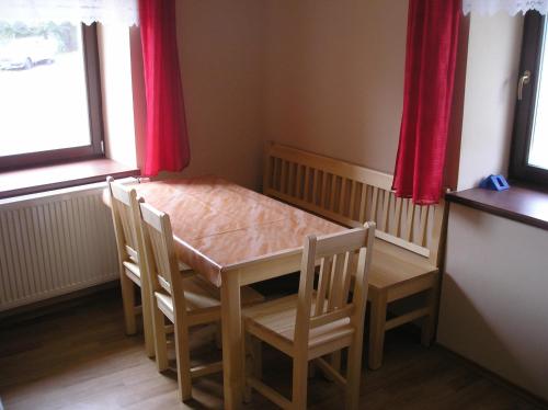 a table and chairs and a crib in a room at Penzion U Dvou slunci in Stachy