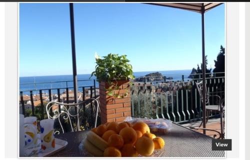 a plate of oranges on a table on a balcony at La Magnolia in Acitrezza