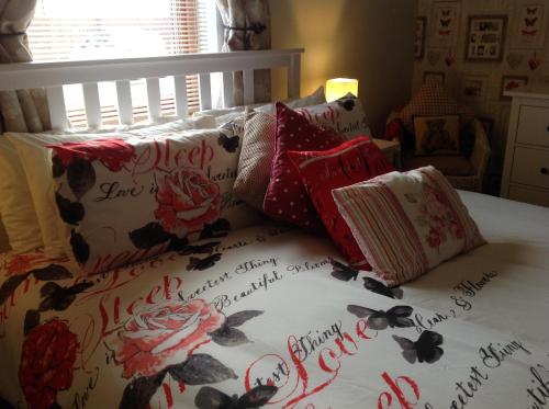a bed with lots of pillows on it at Dunroamin Self-Catering Apartment in Aviemore