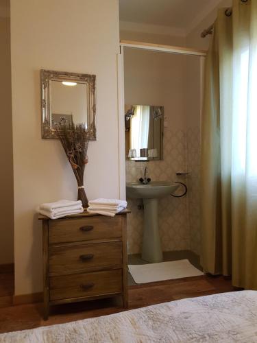 a bathroom with a sink and a vanity with a mirror at Accendi Pipa in Campitello