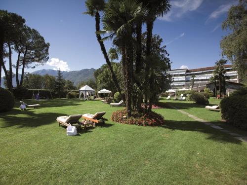 a person laying on a bench in a park at Delta Resort Apartments in Ascona
