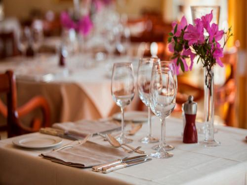 a table with wine glasses and a vase with purple flowers at Delta Resort Apartments in Ascona