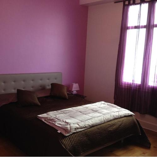 - une chambre avec un lit aux murs violets et des fenêtres dans l'établissement LE MIRAGE, SEA FRONT view, 3 bedrooms, 100m, à Nice