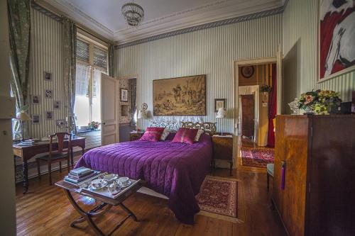 1 dormitorio con cama morada y mesa en Manoir de la Peylouse, en Saint-Venant