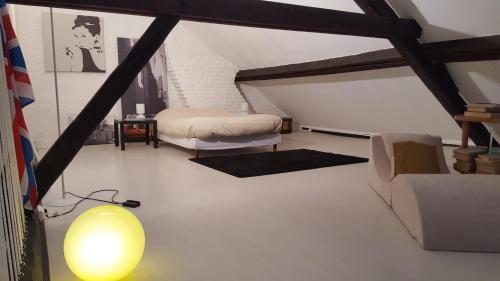 a attic room with a bed and a lamp at Manoir de la Peylouse in Saint-Venant