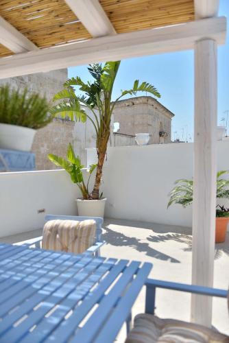 a blue table and chairs on a balcony with plants at Palazzo Kapece in Monopoli