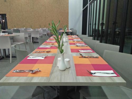 a long table with plates and forks and napkins at Lakeview Terrace Resort Pengerang in Pengerang