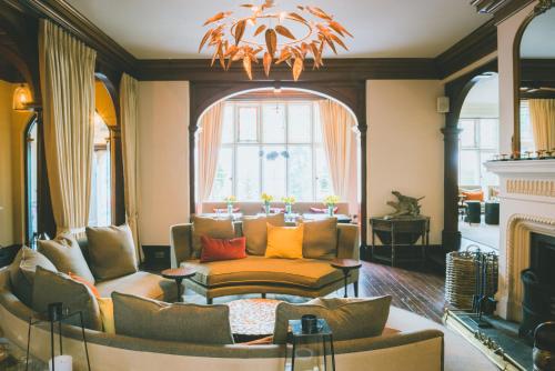 a living room with a couch and a fireplace at The Coed-Y-Mwstwr Hotel in Bridgend